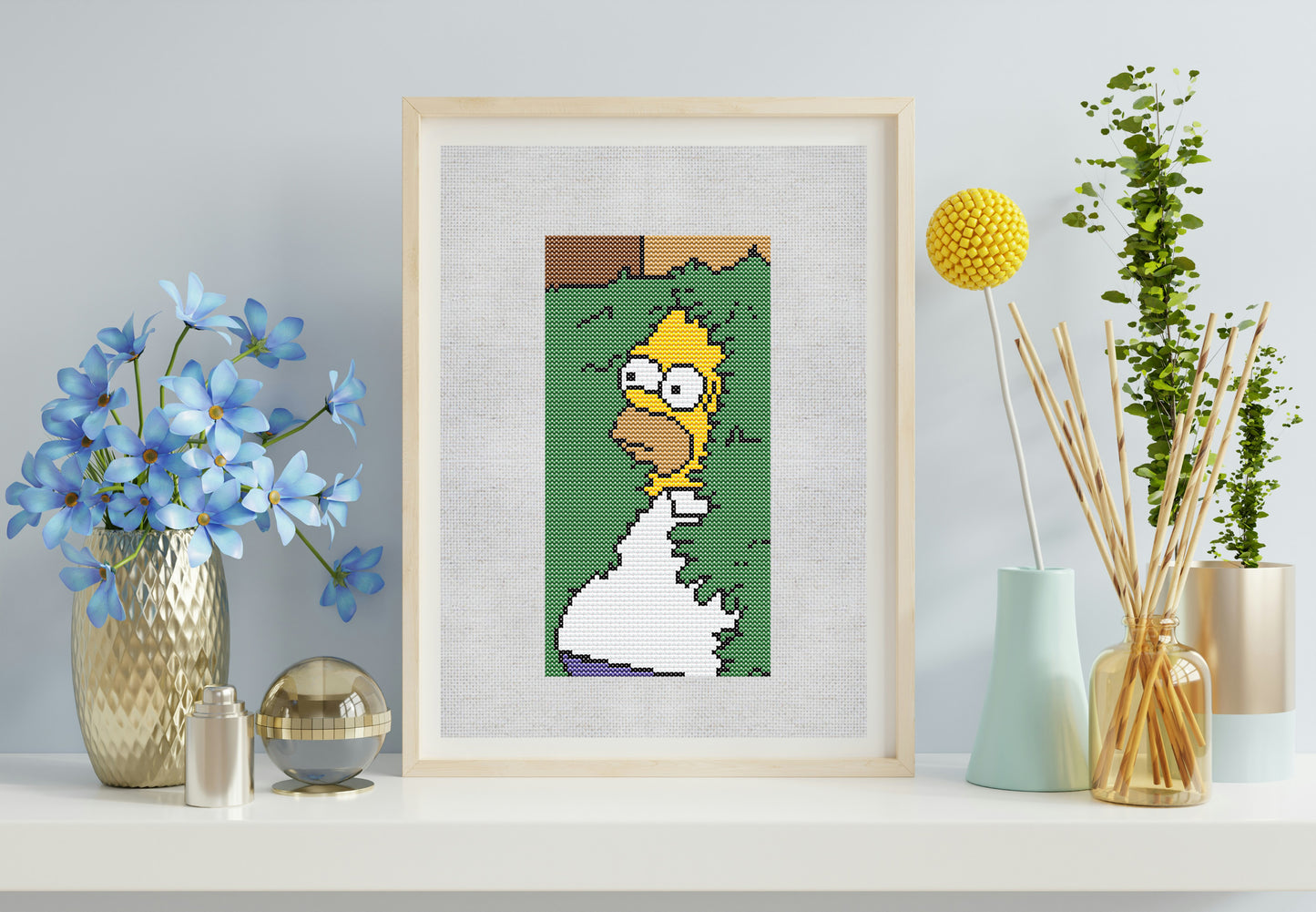 Framed artwork on a shelf with a flowers in the background