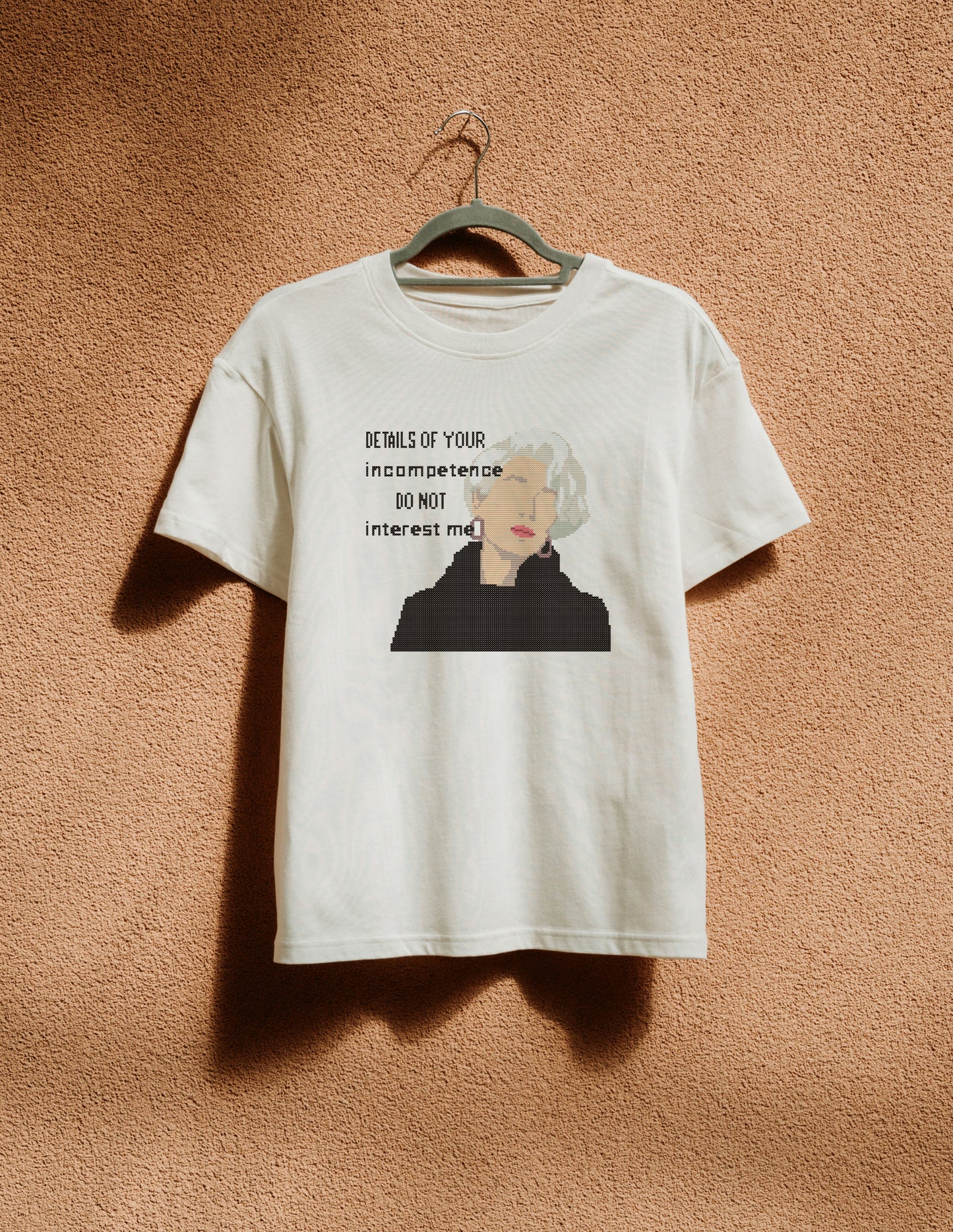 White t-shirt with graphic design and text on a beige background