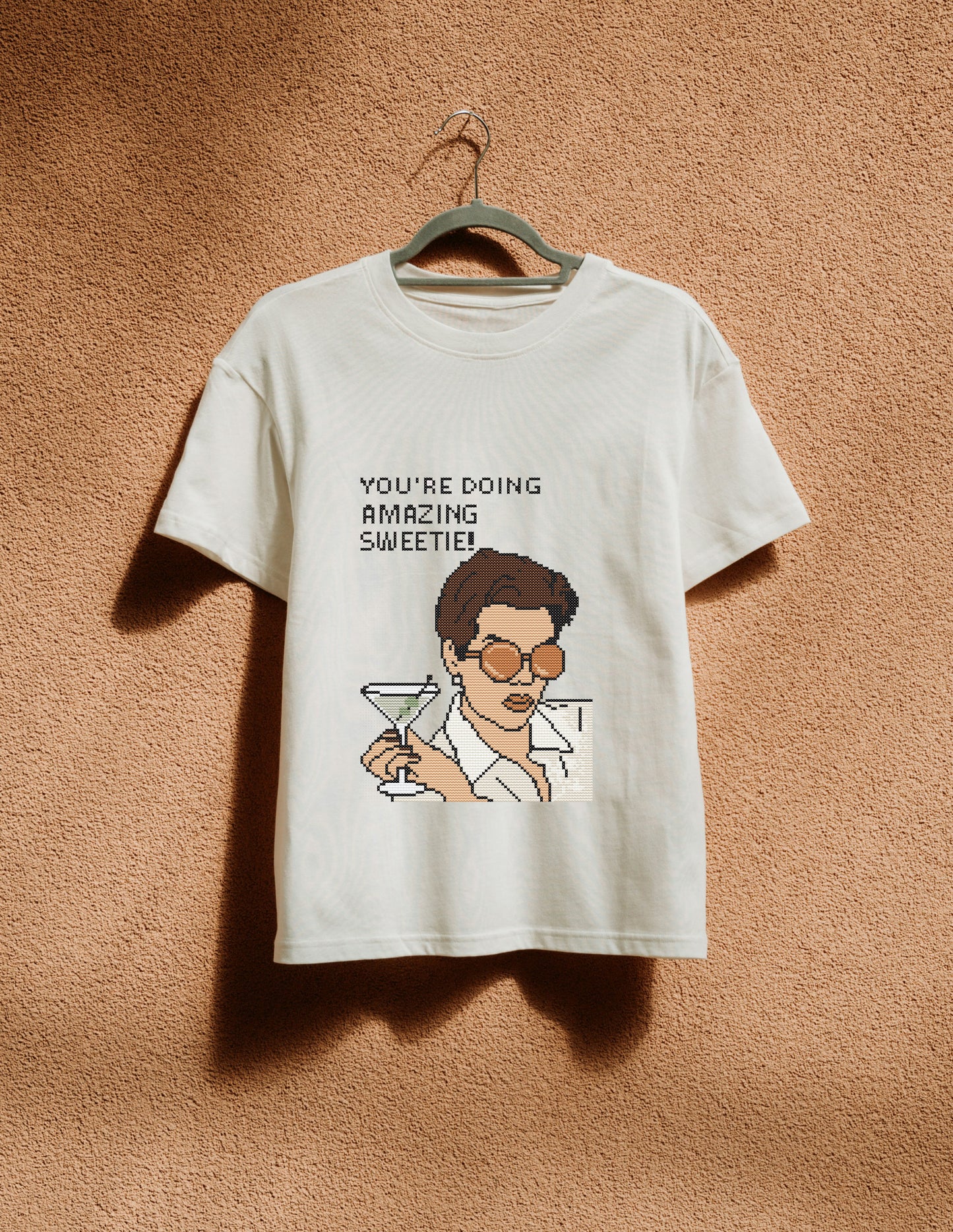 White t-shirt with graphic design and text on a beige background