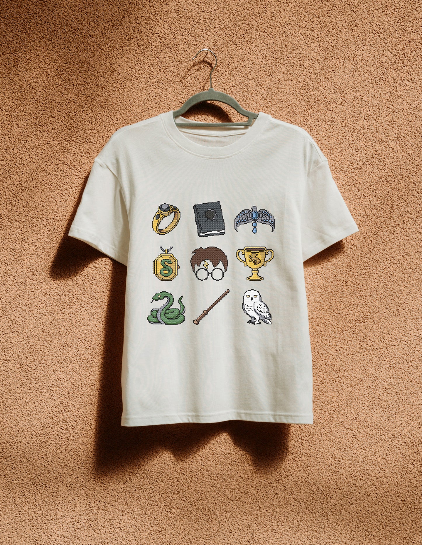 White t-shirt with Harry Potter-themed graphics on a beige wall