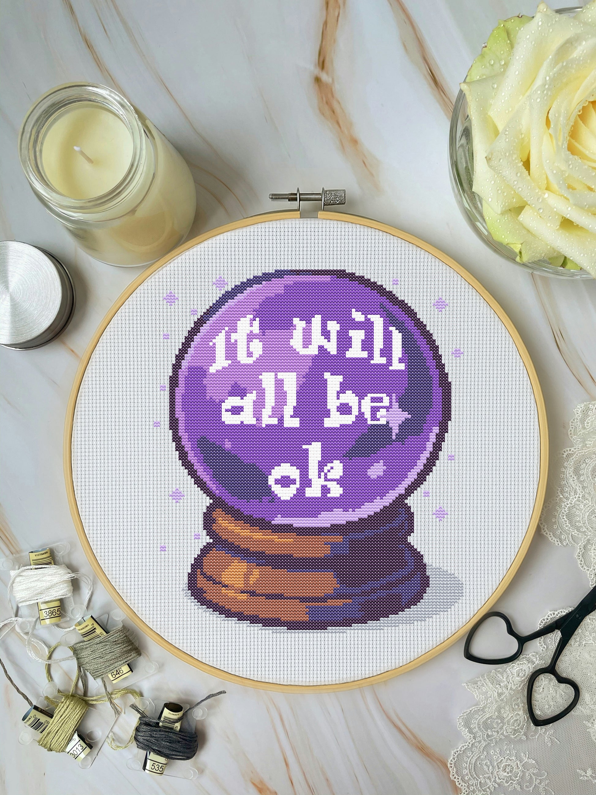 Cross-stitch pattern for a crystal ball with text 'It will all be ok' on a white background.