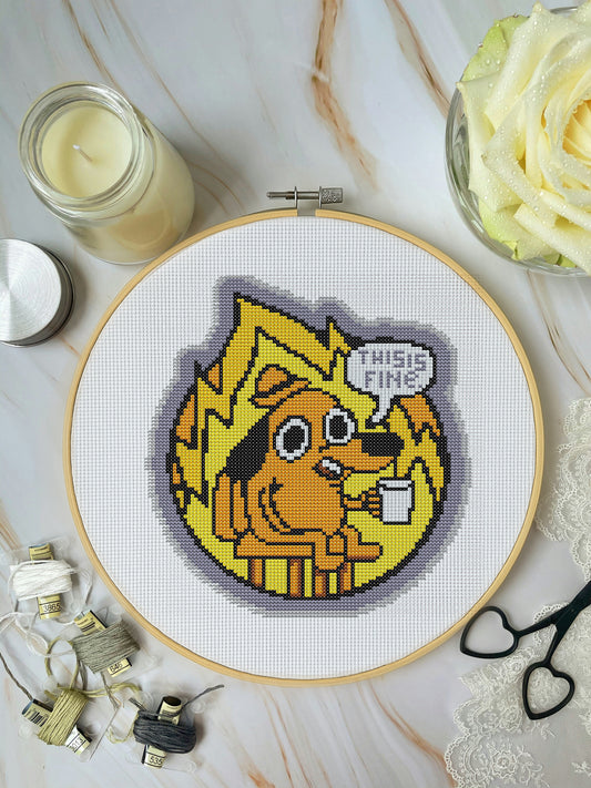 Cross-stitched design of a cartoon character with text 'This is fine!' on a white background.