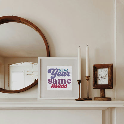 Decorative mantel with a mirror, framed print, and candles.