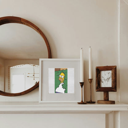 Framed artwork on a shelf with a mirror and candles in the background