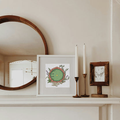 Decorative items on a mantelpiece including a mirror, framed artwork, and candles.
