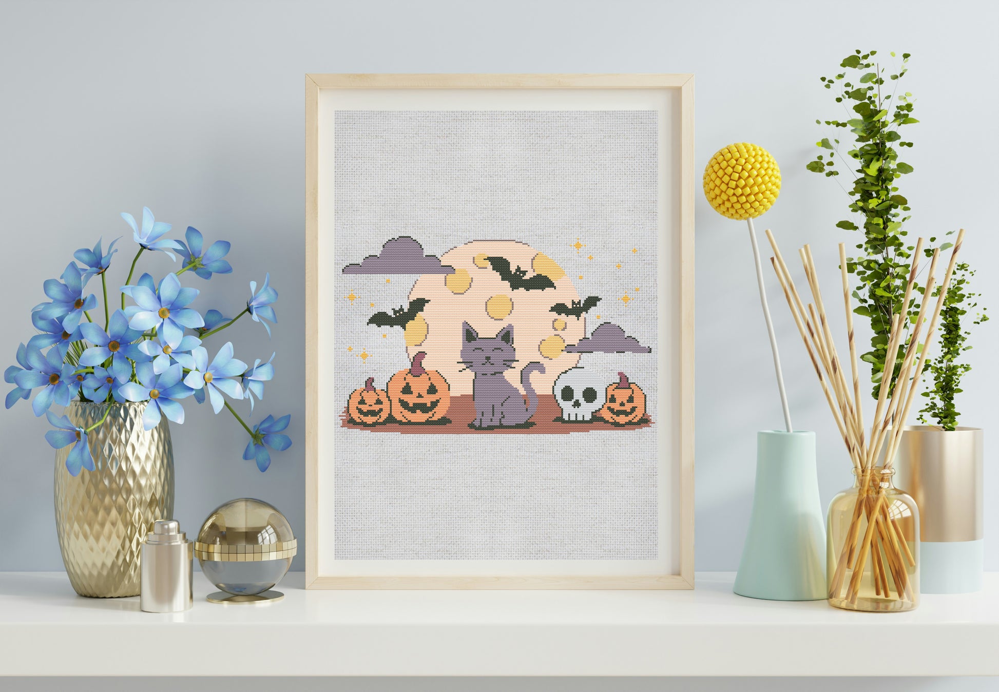 Framed Halloween-themed artwork on a shelf with decorative items.