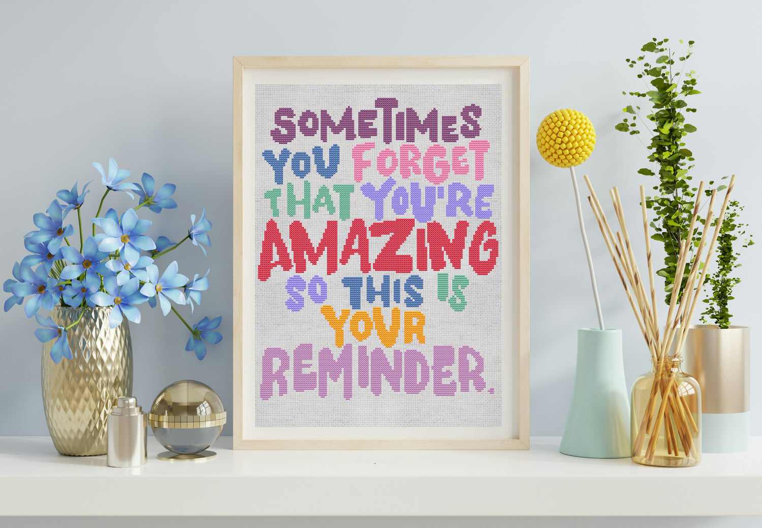 Framed motivational poster with colorful text in a home setting with decor items.