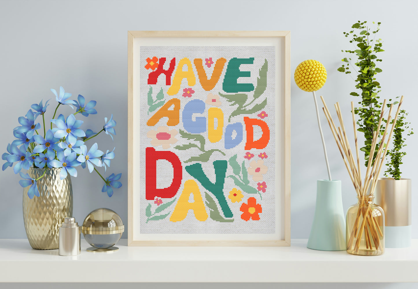 Framed colorful artwork with 'Have a Good Day' text on a shelf with decorative items.