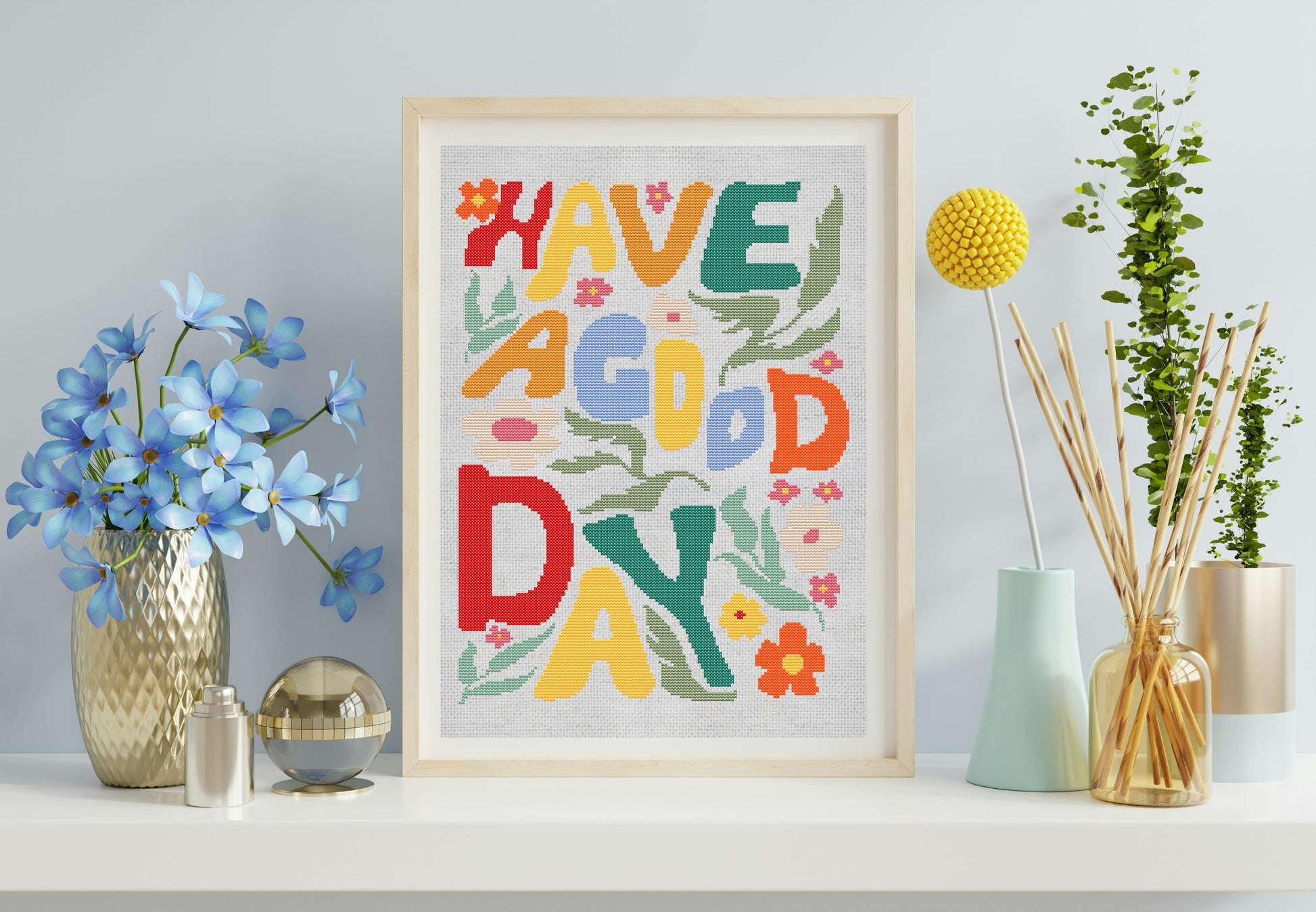 Framed colorful artwork with 'Have a Good Day' text on a shelf with decorative items.