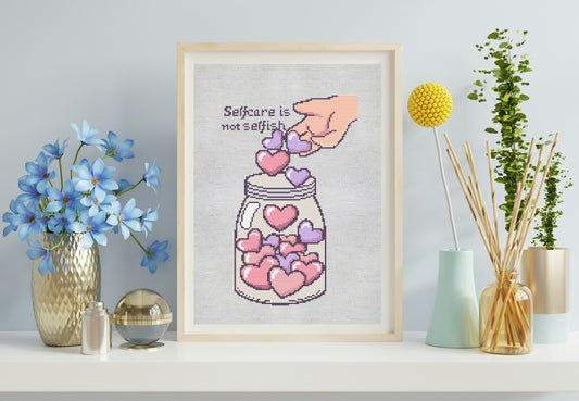 Framed cross-stitch art of a mason jar with hearts and a quote on a wall with decorative items.