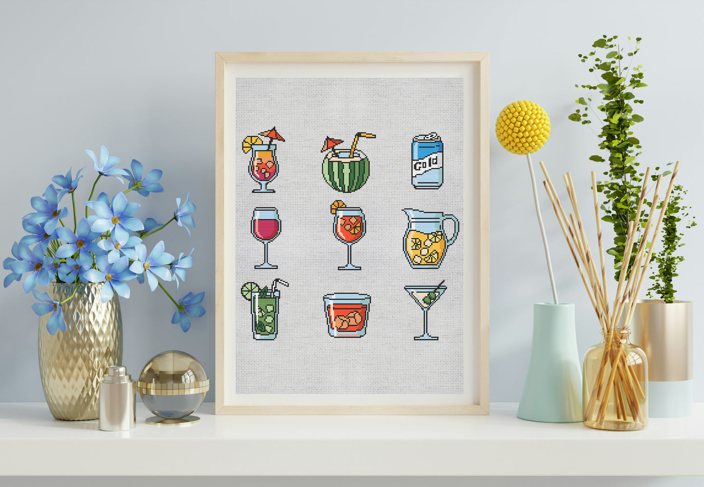 Framed artwork of colorful cocktails on a white wall with decorative items.