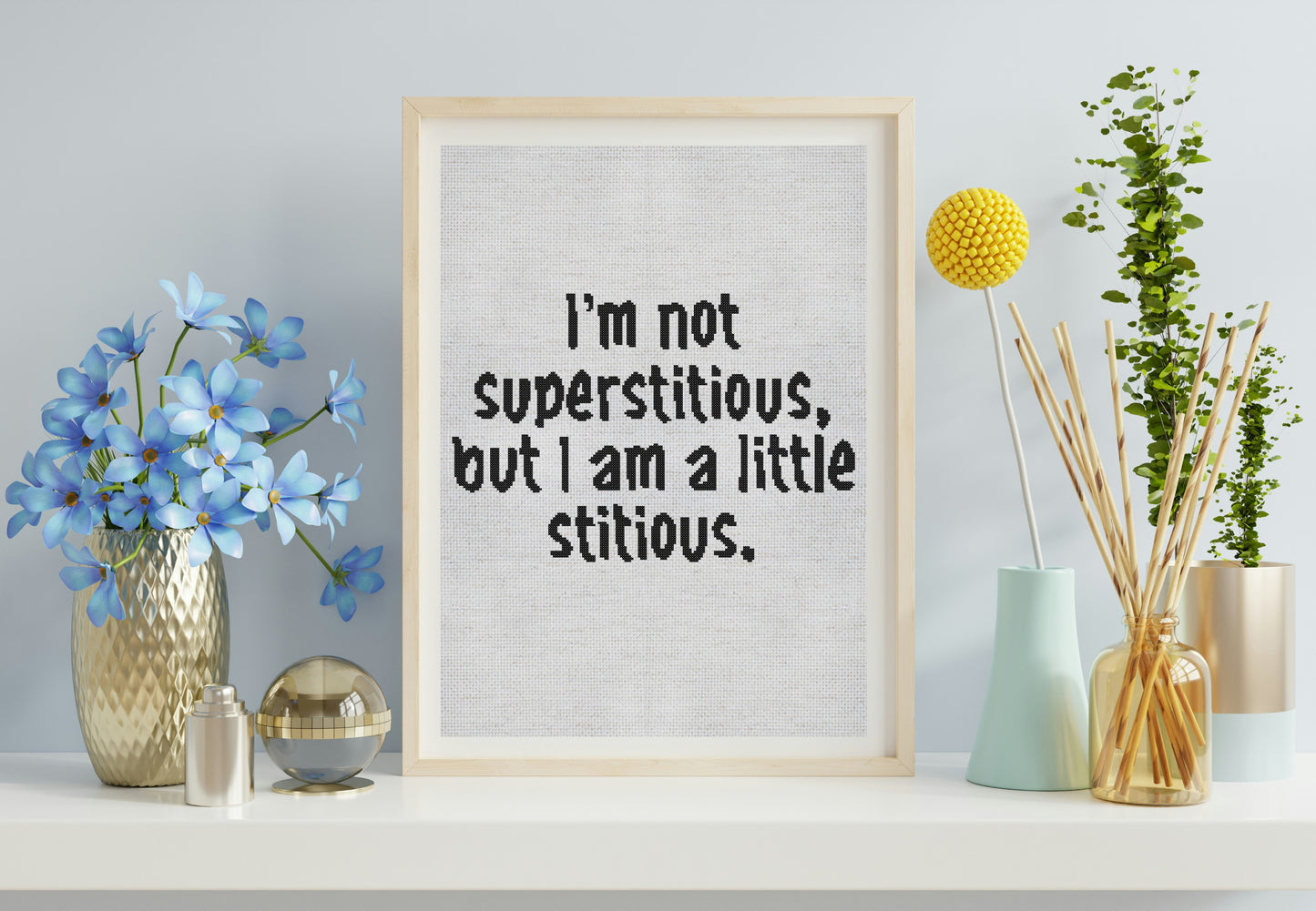 Framed print with humorous text on a shelf with decorative items