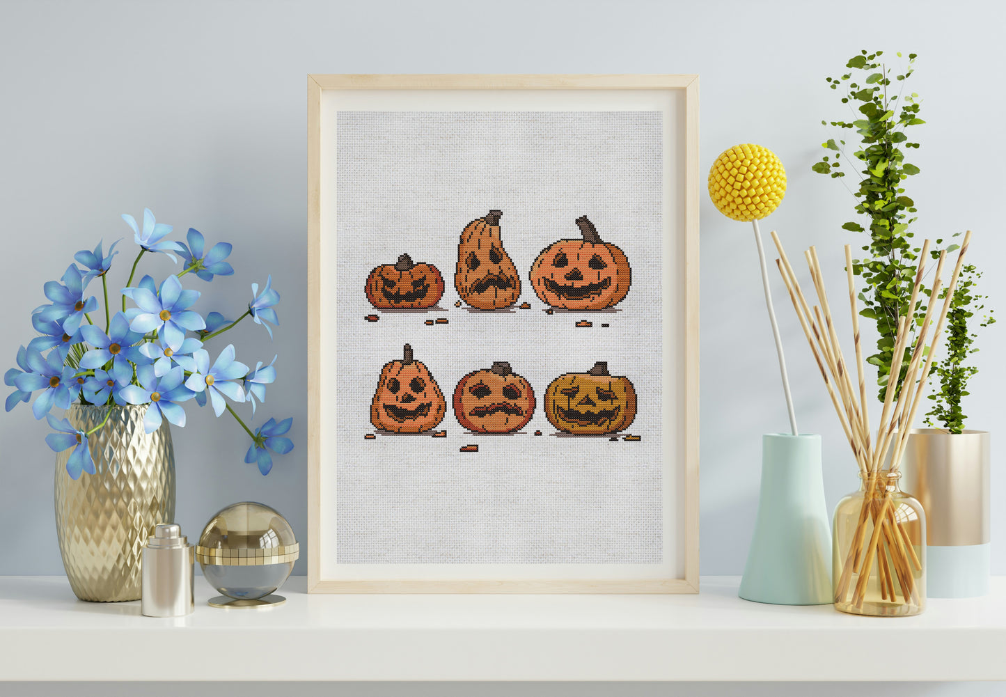 Framed artwork of pumpkins on a wall with decorative vases and plants.
