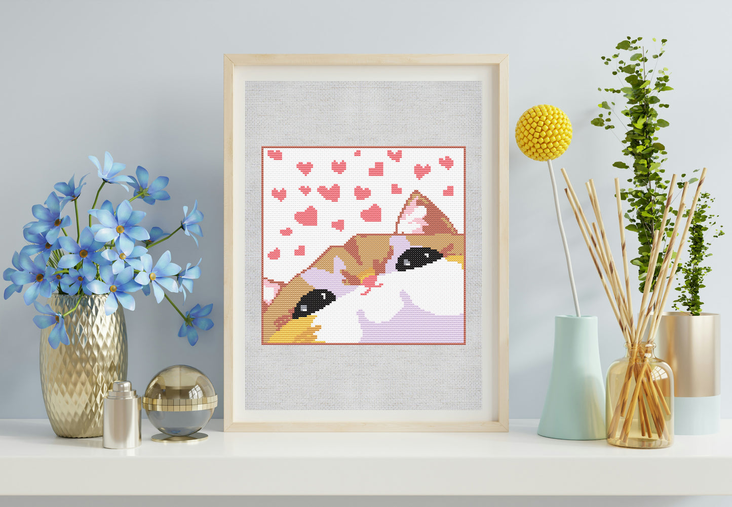 Framed artwork of two cats with hearts on a light gray wall, surrounded by decorative items.