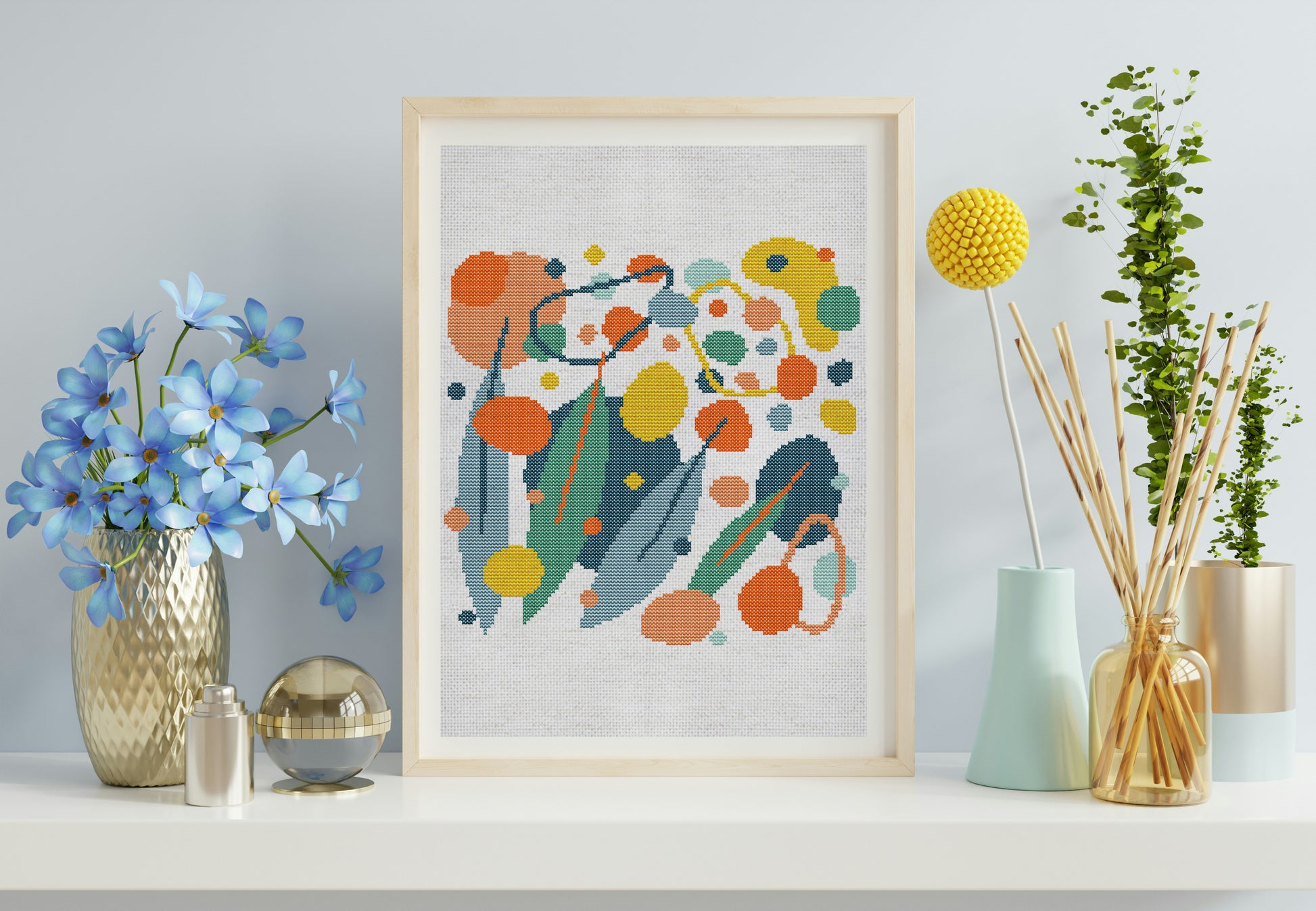 Framed abstract artwork with colorful flowers on a shelf with decorative items.