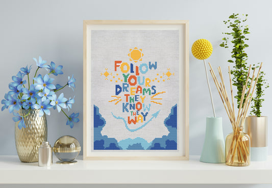 Framed artwork with motivational quote 'Follow your dreams, they know the way' on a shelf with decorative items.