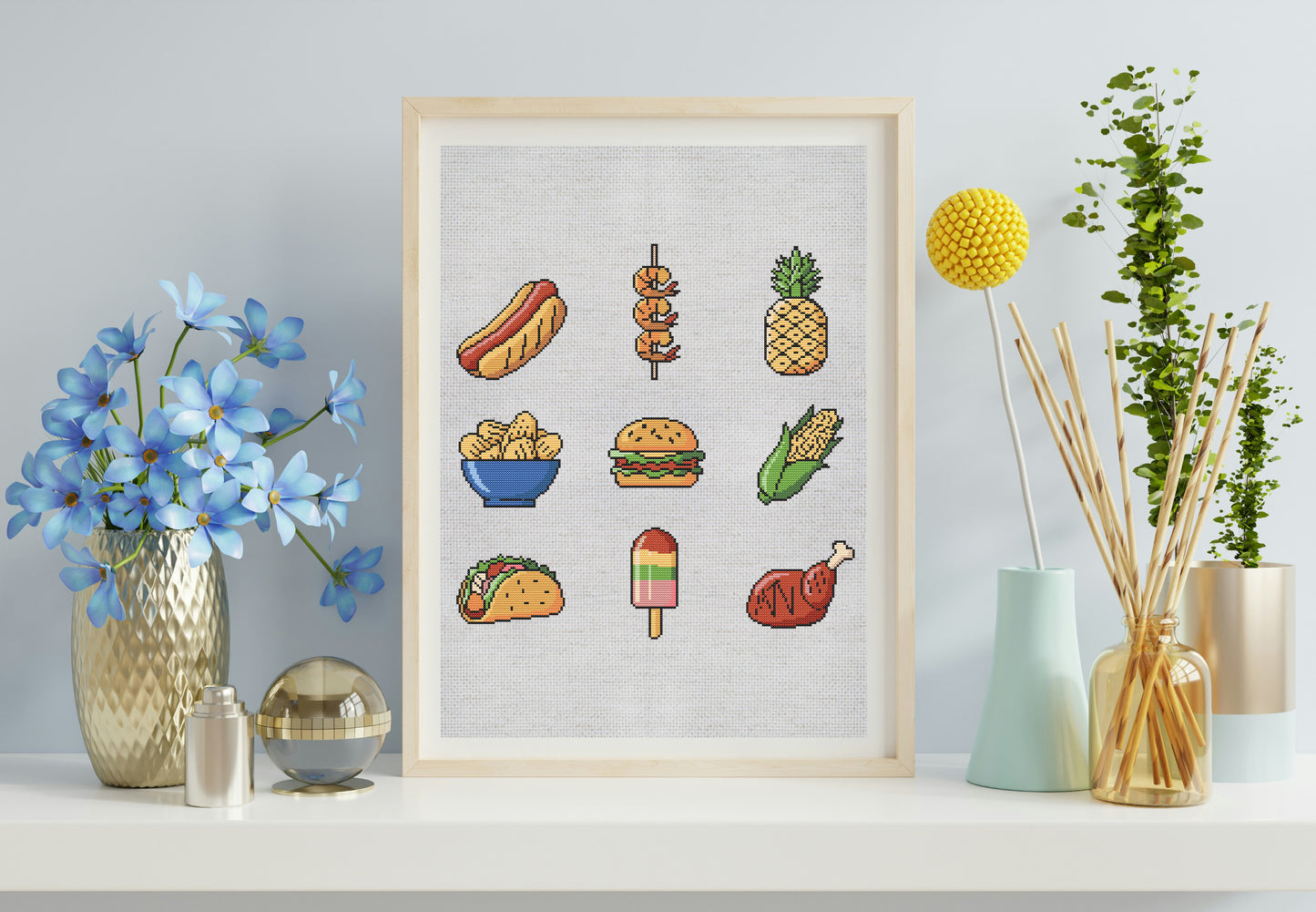 Framed artwork with colorful illustrations of food items on a light gray wall.