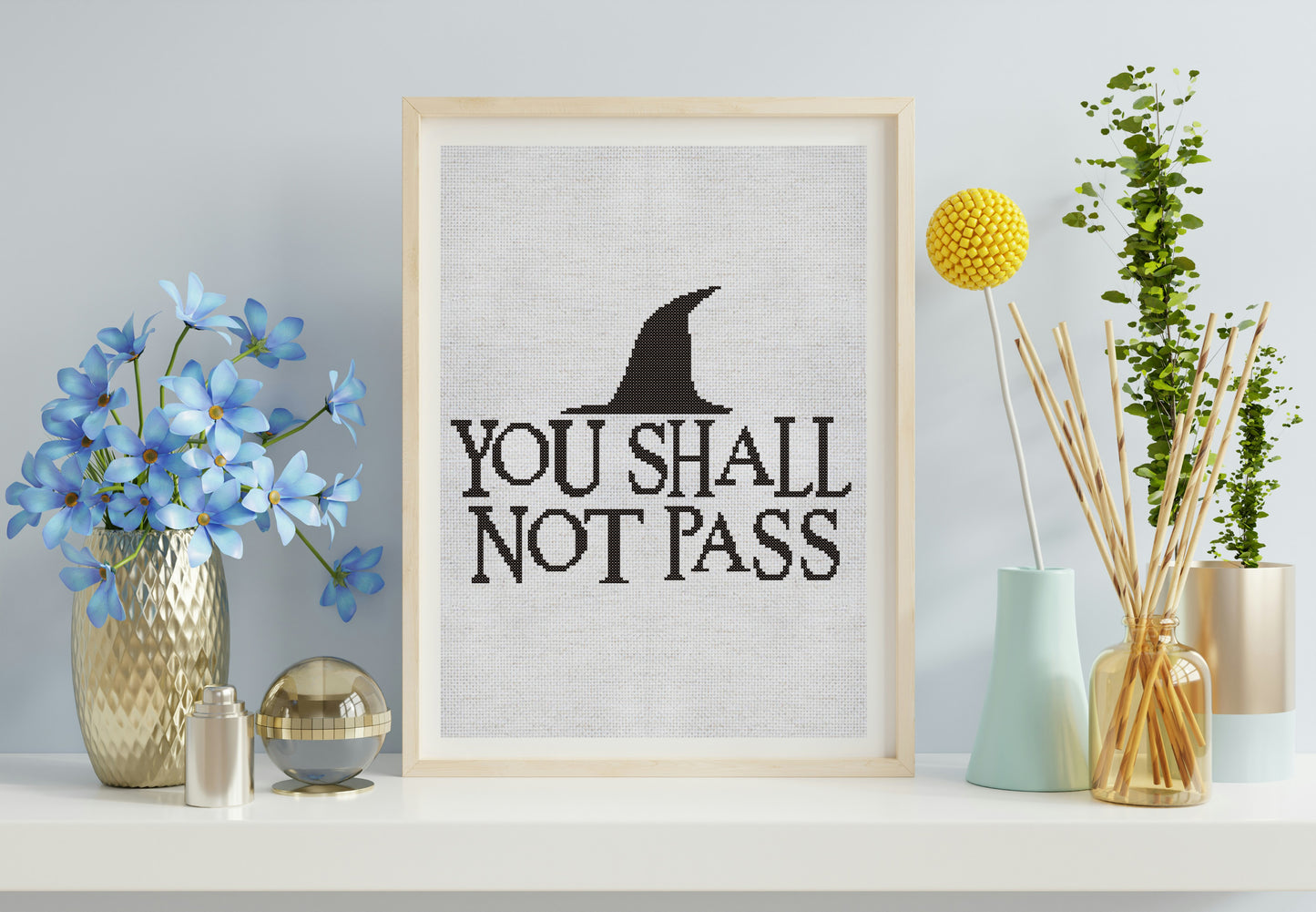 Framed artwork with 'You Shall Not Pass' quote and black witch hat on a light gray wall.