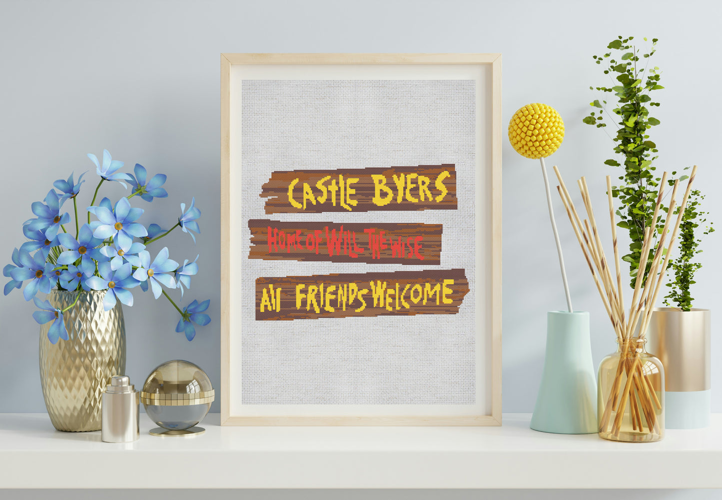 Framed sign with text 'Castle Byers Where Wild Things Are Friends Welcome' on a shelf with decorative items.