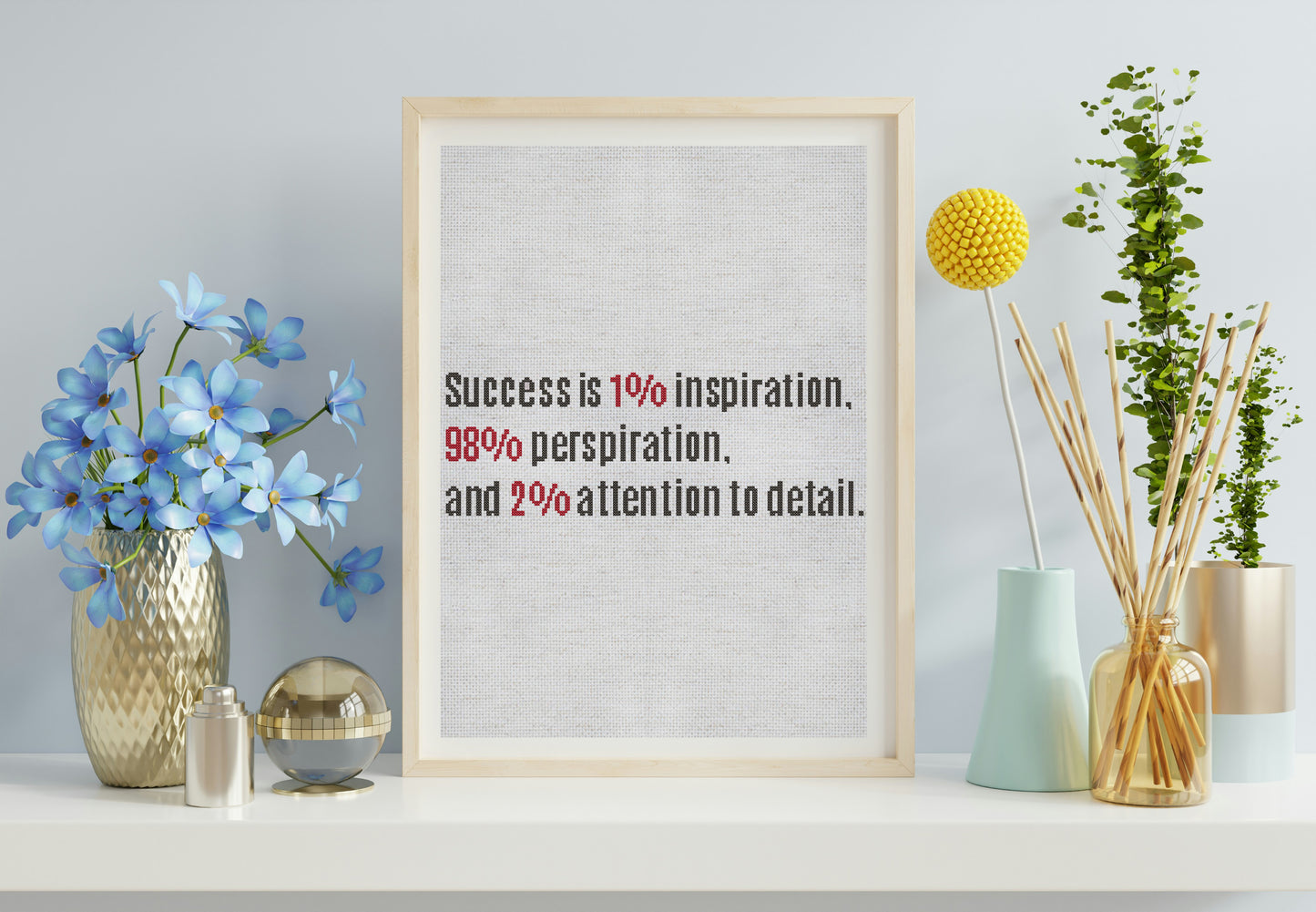 Framed motivational quote on a wall with decorative items including flowers and vases.