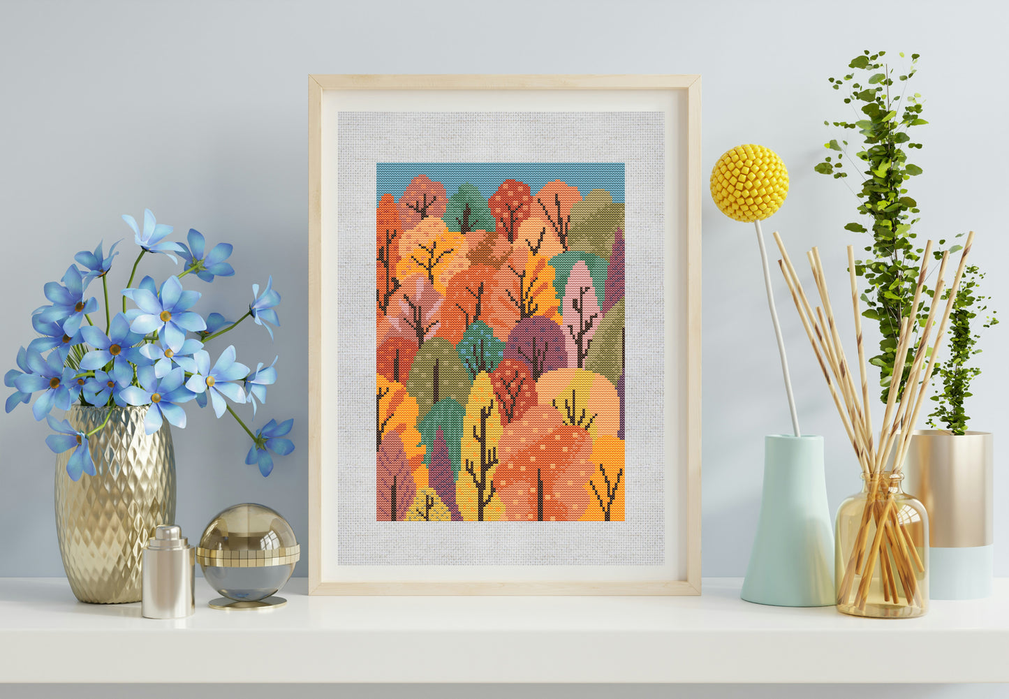 Framed artwork of a colorful forest scene on a shelf with decorative items.