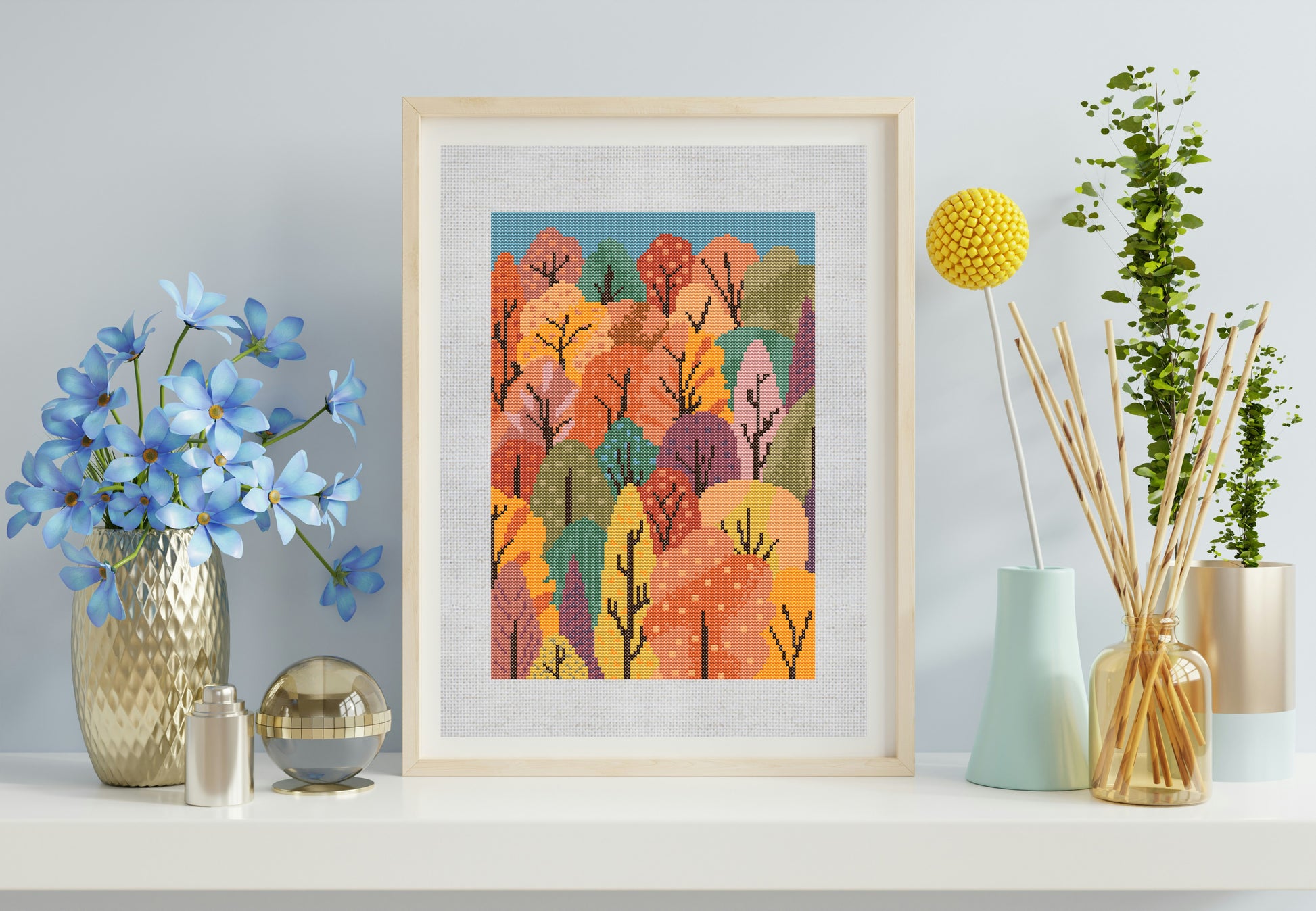 Framed artwork of a colorful forest scene on a shelf with decorative items.