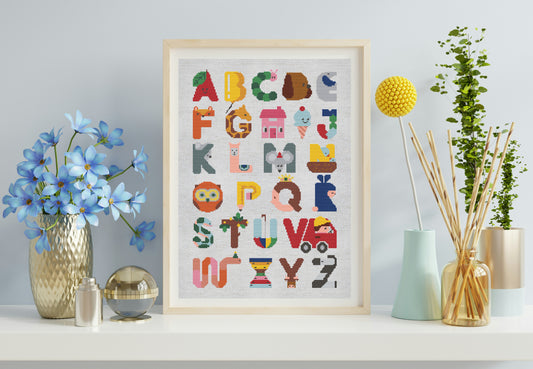Framed alphabet poster on a shelf with decorative items