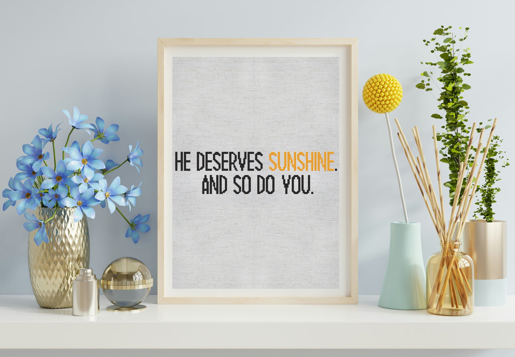 Framed print with motivational quote on a shelf with decorative items