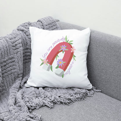 Decorative pillow with a pink letter 'A' and text on a gray couch.