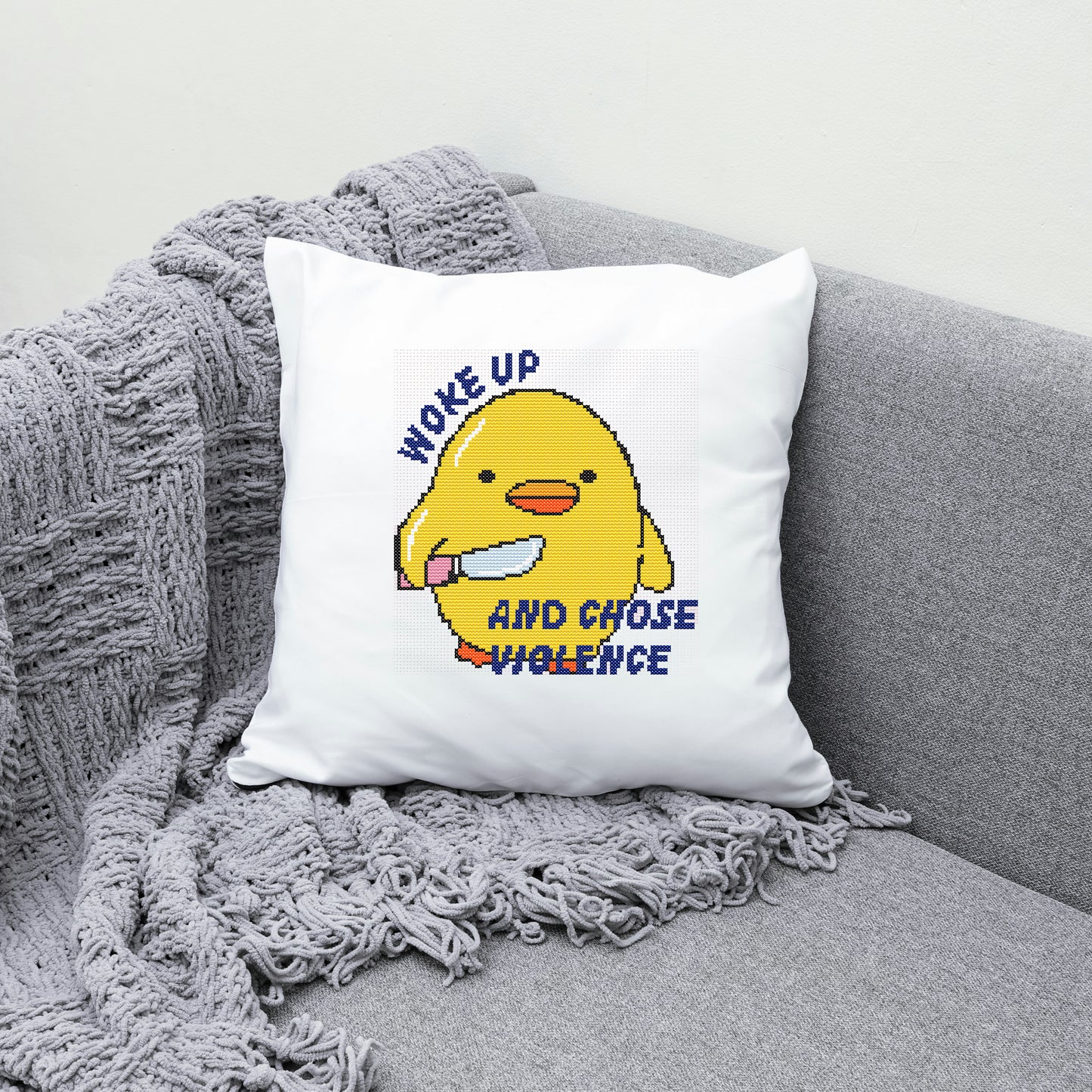 White pillow with a yellow character and text on a gray couch
