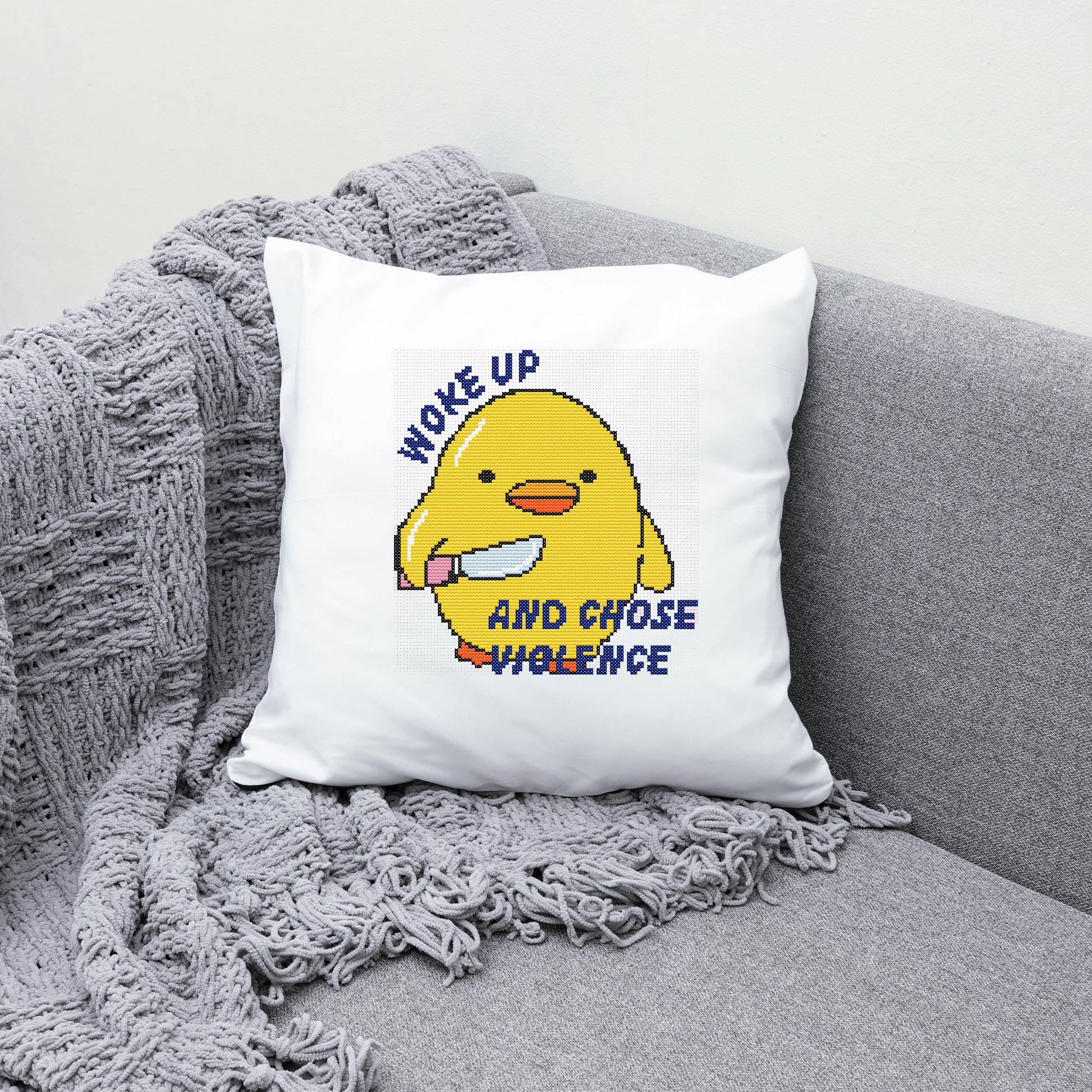 White pillow with a yellow character and text on a gray couch