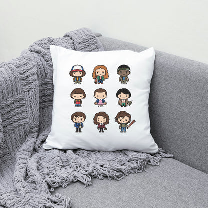 White pillow with pixel art character designs on a gray couch