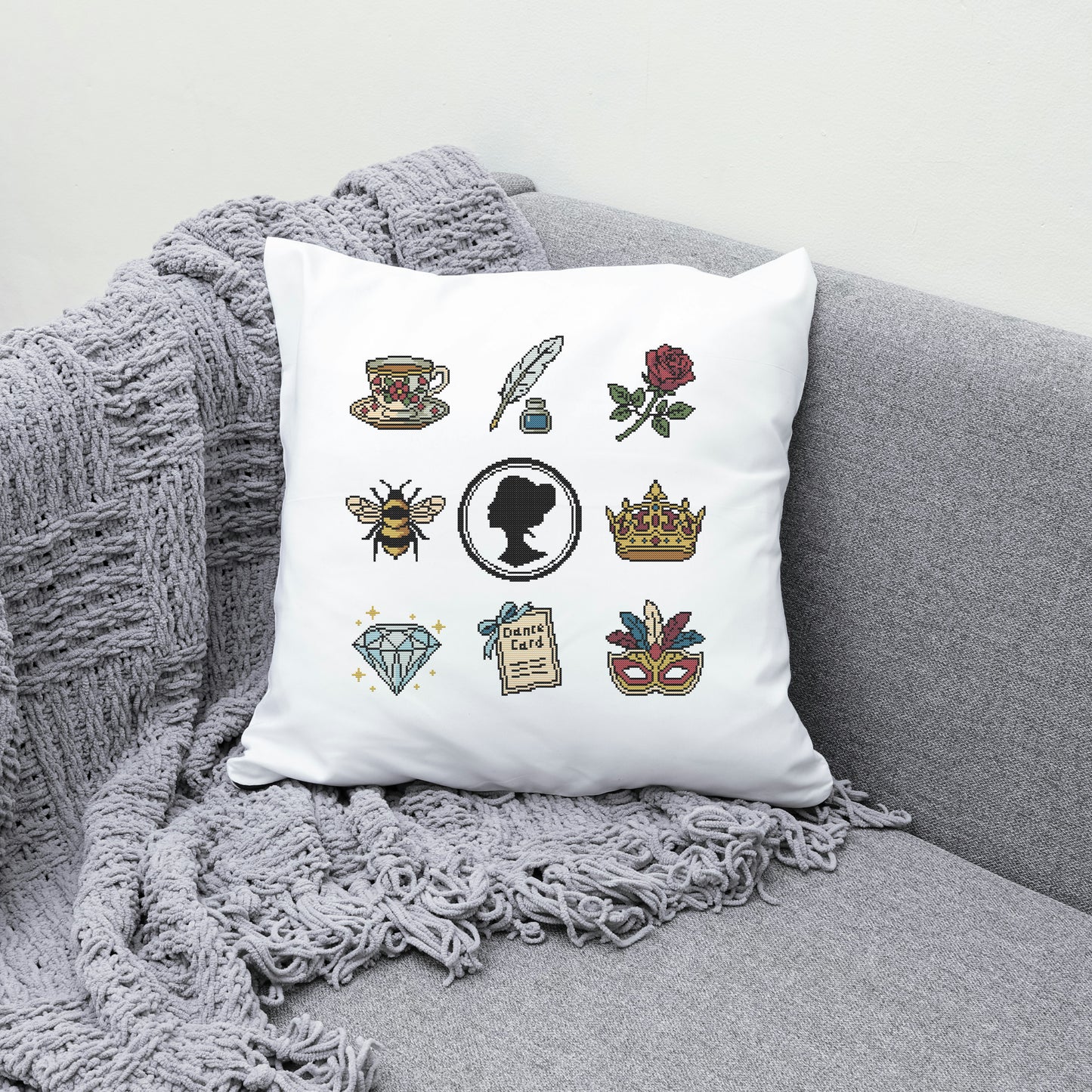 Decorative pillow with various illustrations on a gray couch