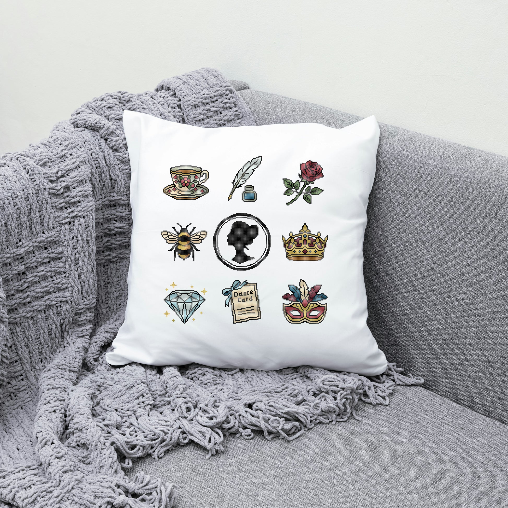 Decorative pillow with various illustrations on a gray couch