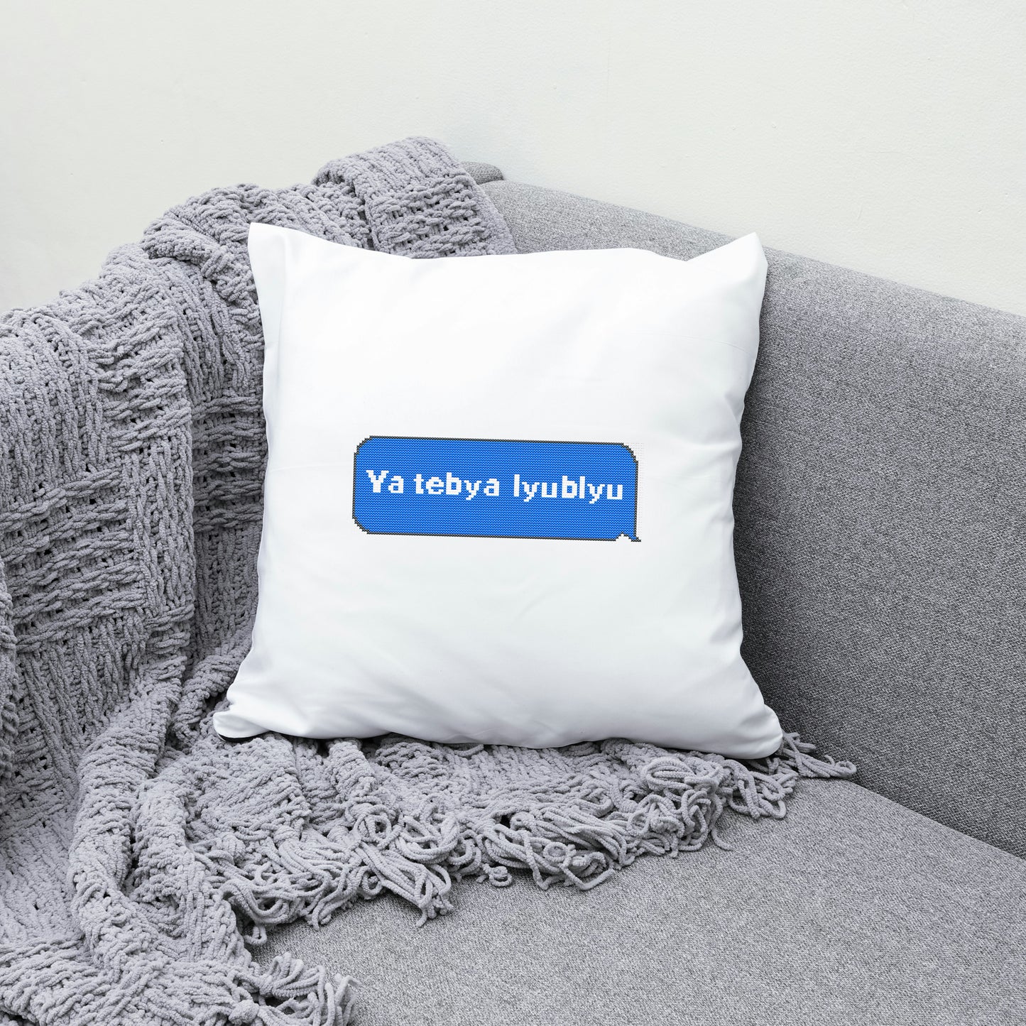 White pillow with a blue text box on a gray couch