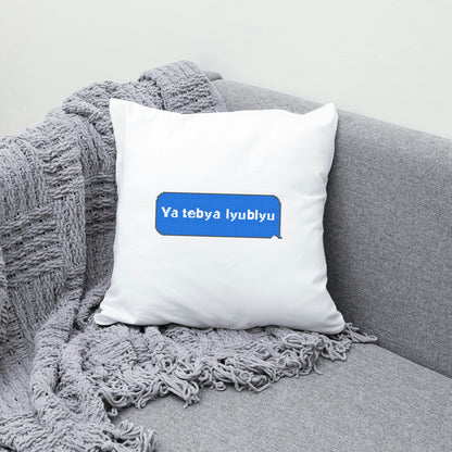 White pillow with a blue text box on a gray couch