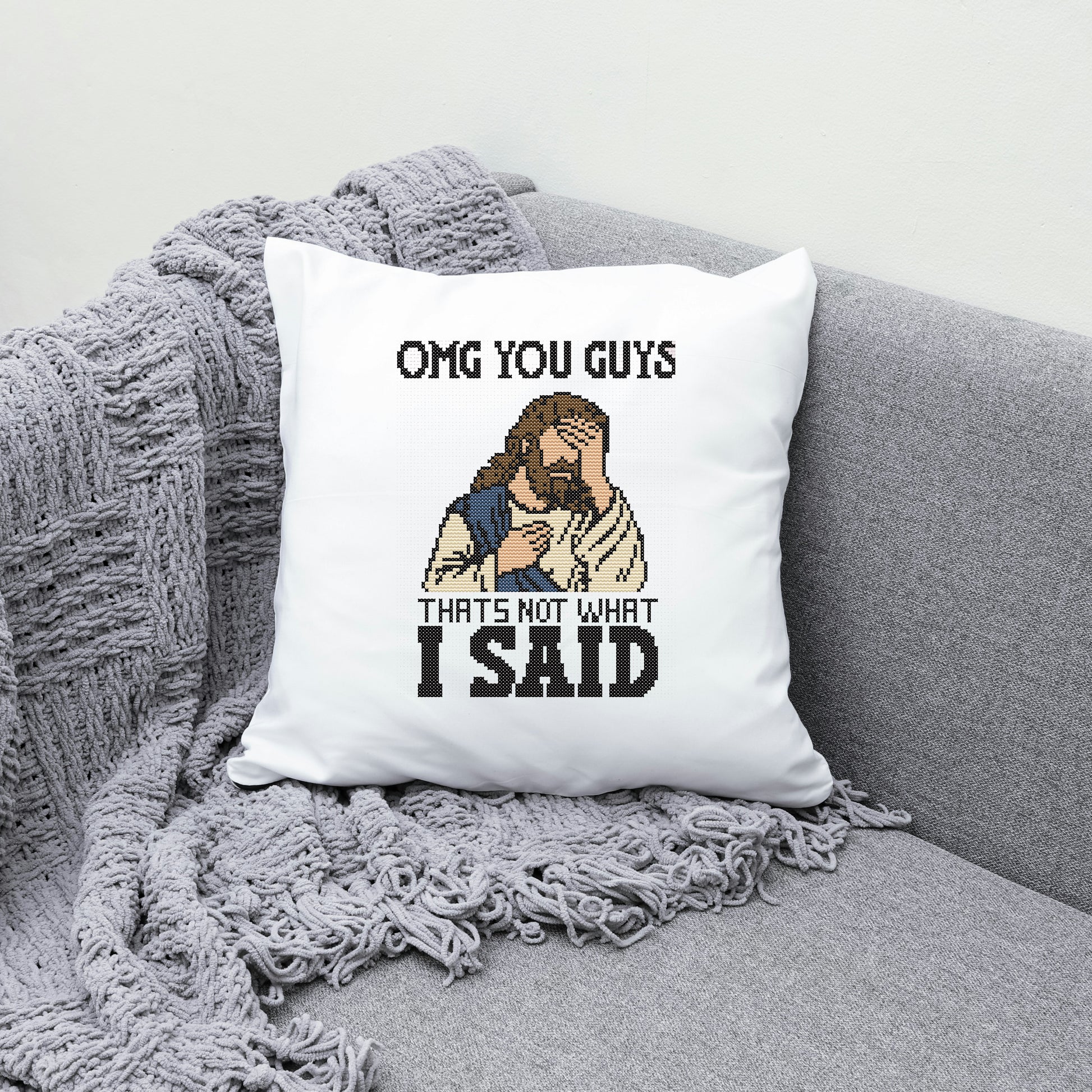 Pillow with a humorous design of a character and text on a gray couch.