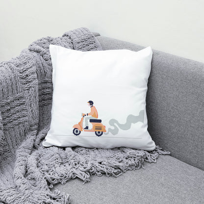 White pillow with a design of a person on a scooter on a gray couch with a textured blanket.