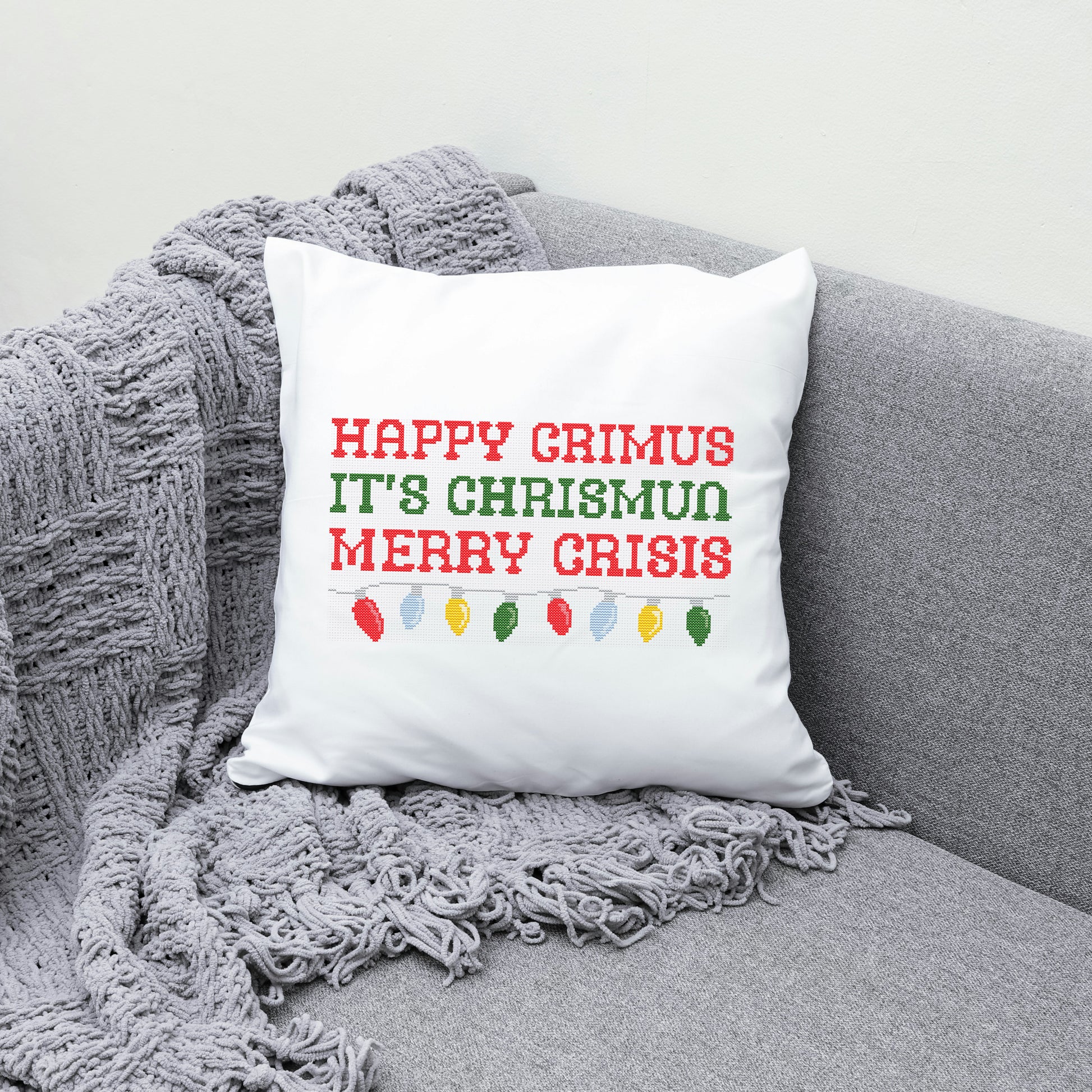White pillow with red text on a gray couch