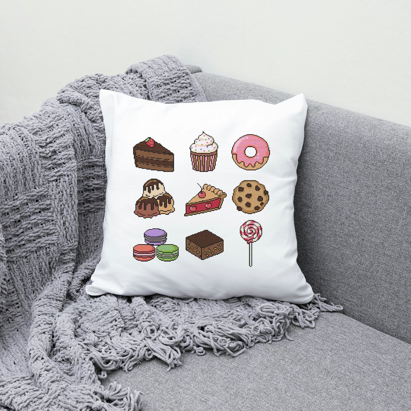 White pillow with dessert illustrations on a gray couch
