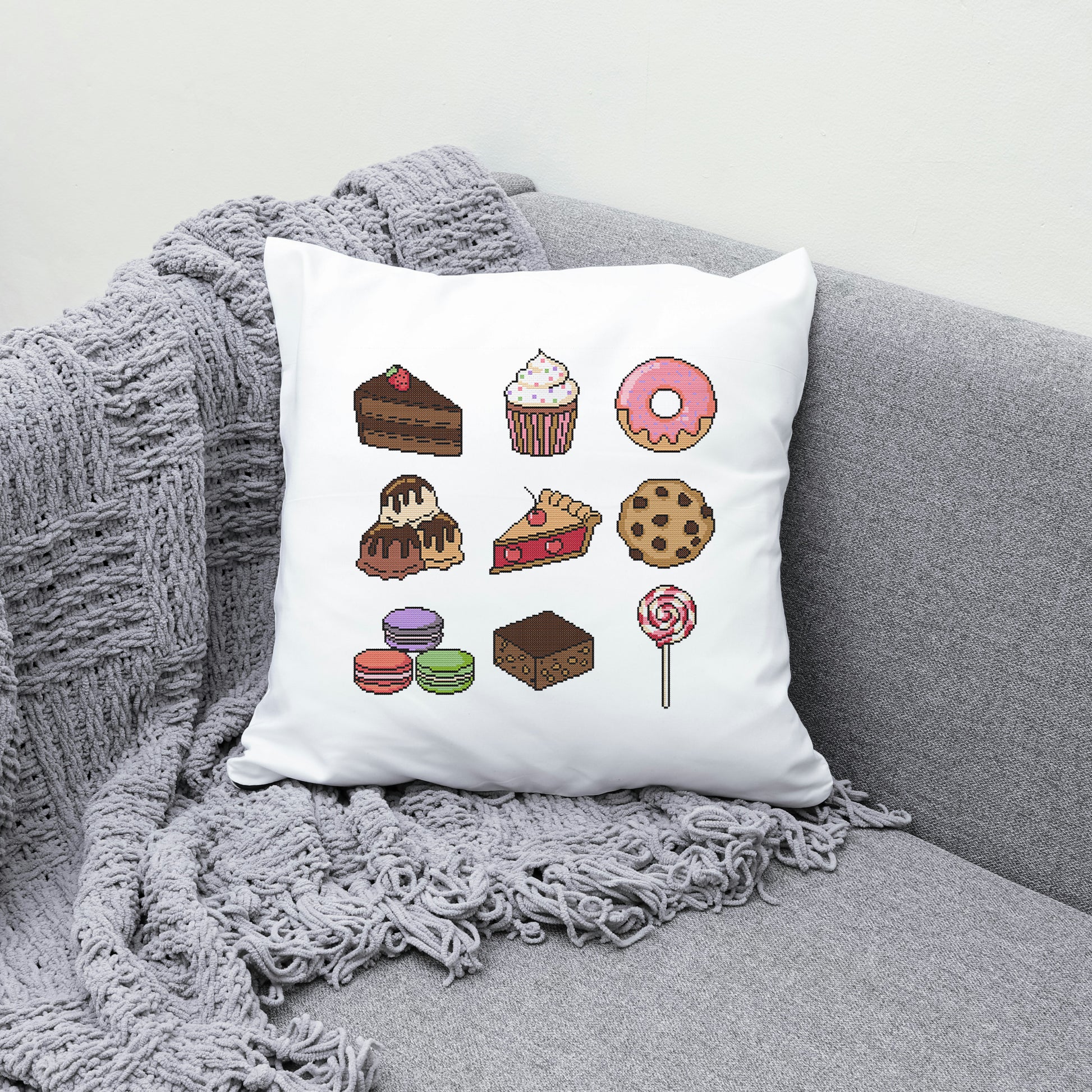 White pillow with dessert illustrations on a gray couch