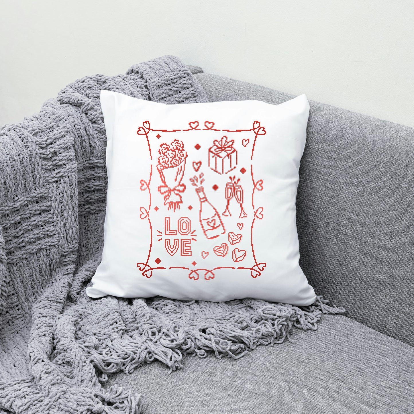 White pillow with red 'LOVE' design on a gray couch