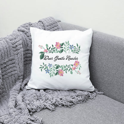 Decorative pillow with floral design and text on a gray couch