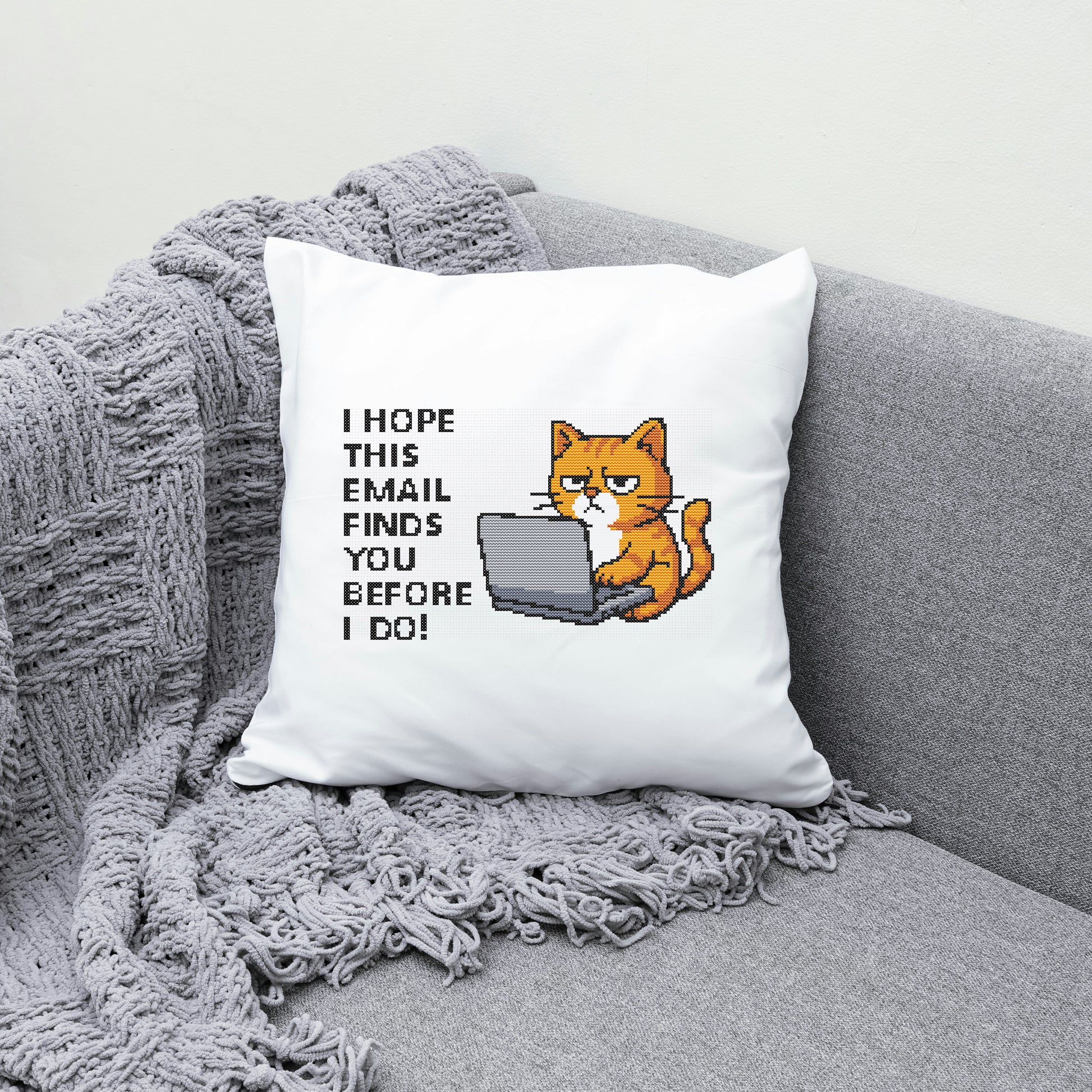 Pillow with a cat illustration and text on a gray couch