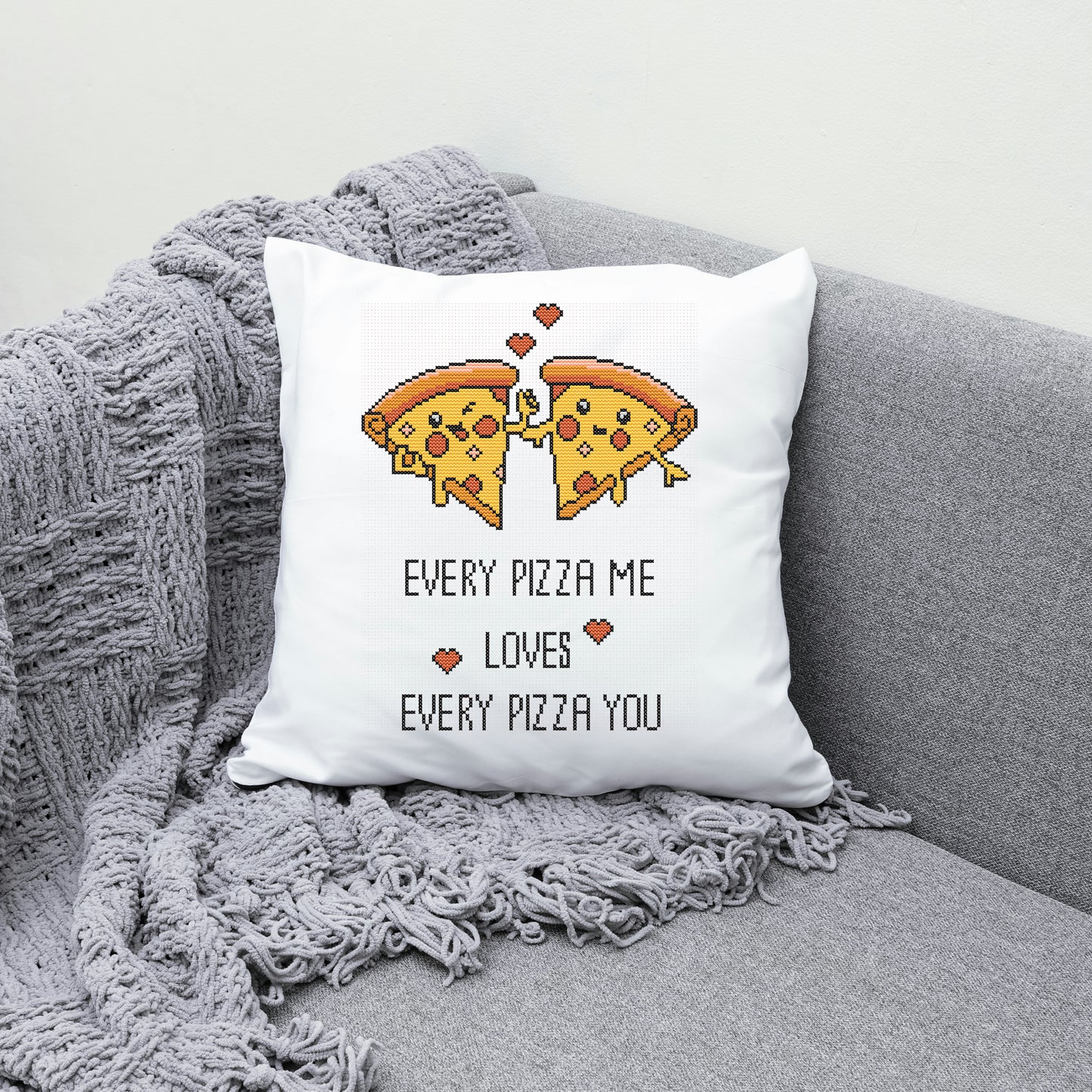 White pillow with pizza design and text on a gray couch