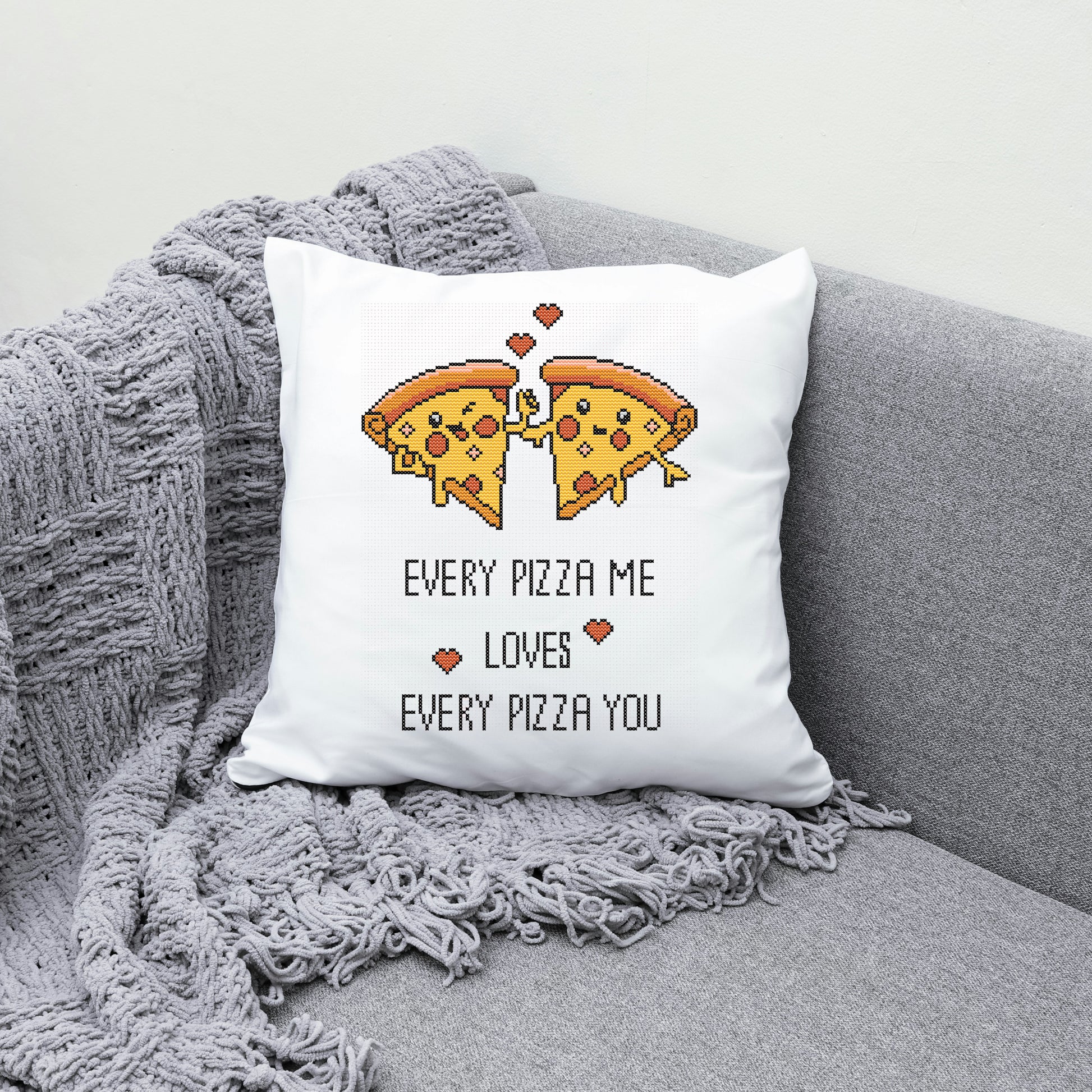 White pillow with pizza design and text on a gray couch