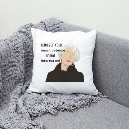 Pillow with a quote and a person's face on a gray couch with a blanket.