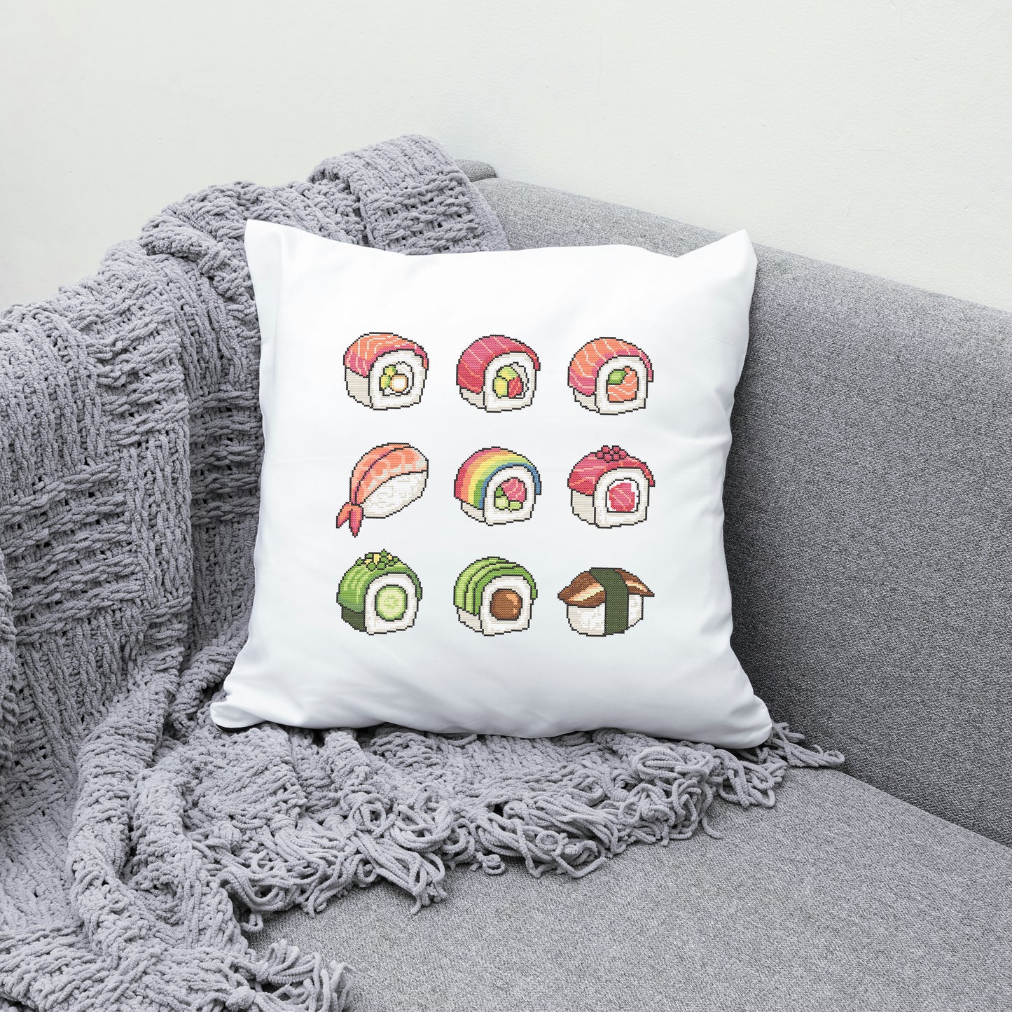 White pillow with colorful sushi illustrations on a gray couch