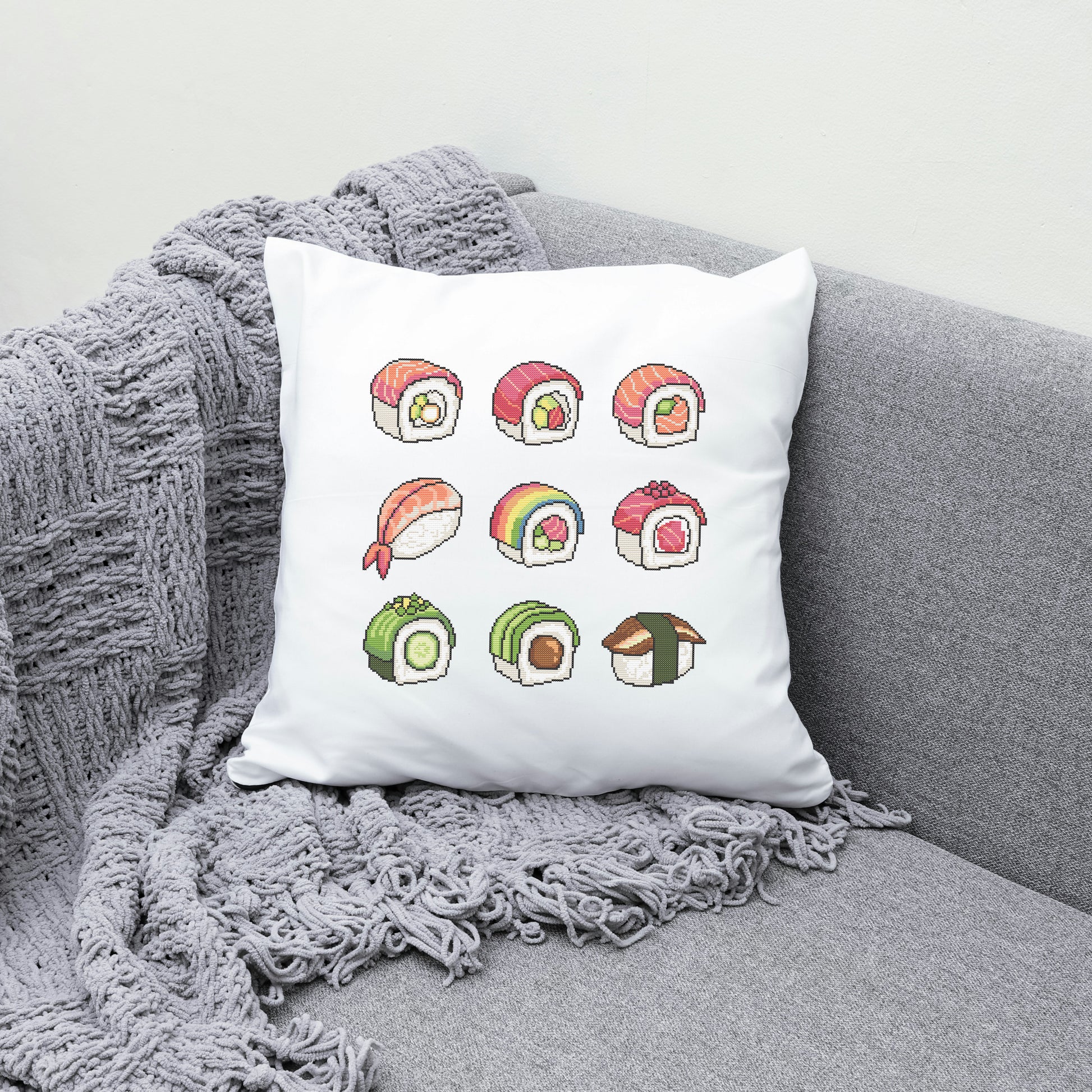 White pillow with colorful sushi illustrations on a gray couch