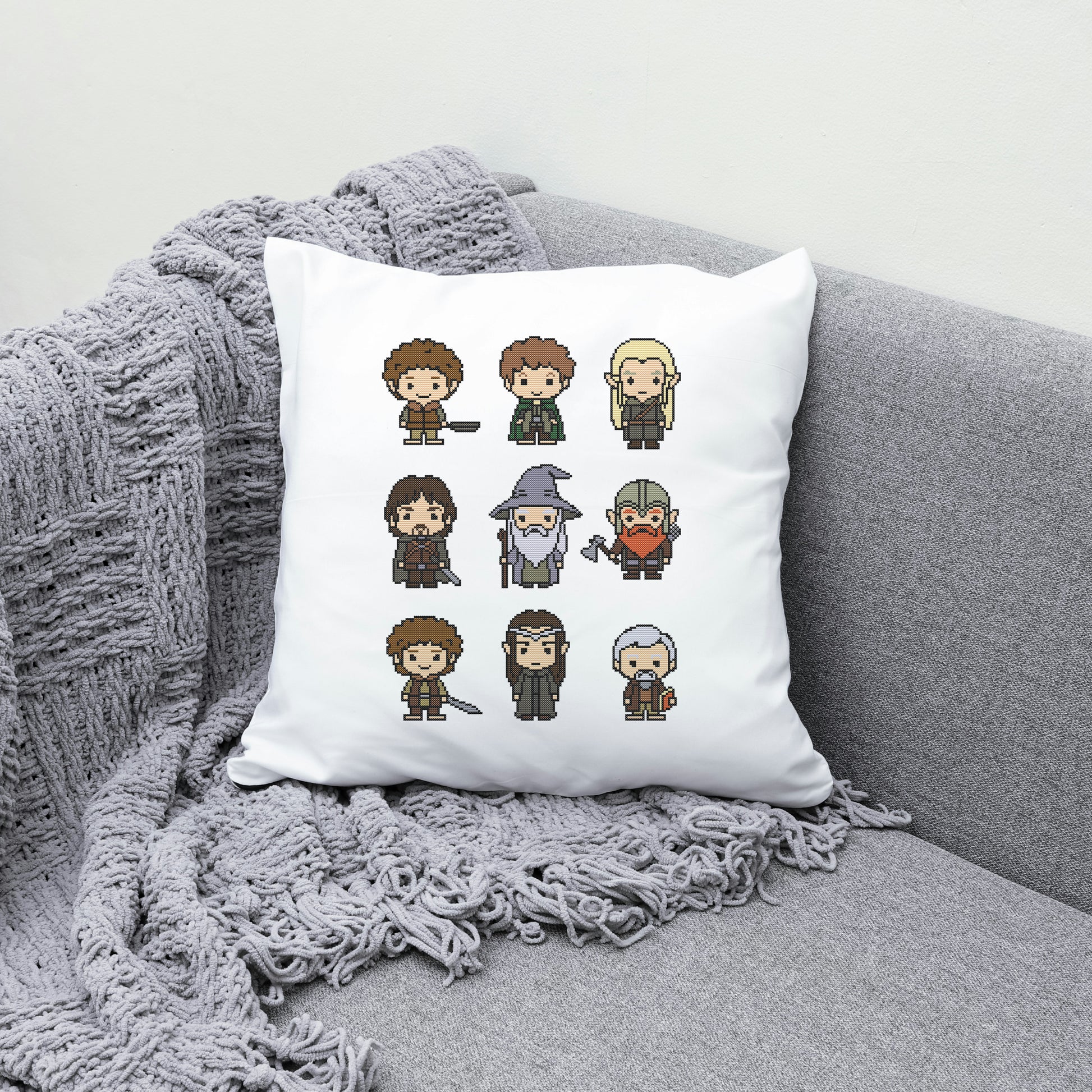 White pillow with pixel art character designs on a gray couch